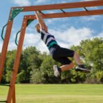 Backyard Discovery Skyfort II Cedar Wood Playset Swing Set with Raised Clubhouse Wave Slide Monkey Bars and Rock Climbing Wall - Image 6